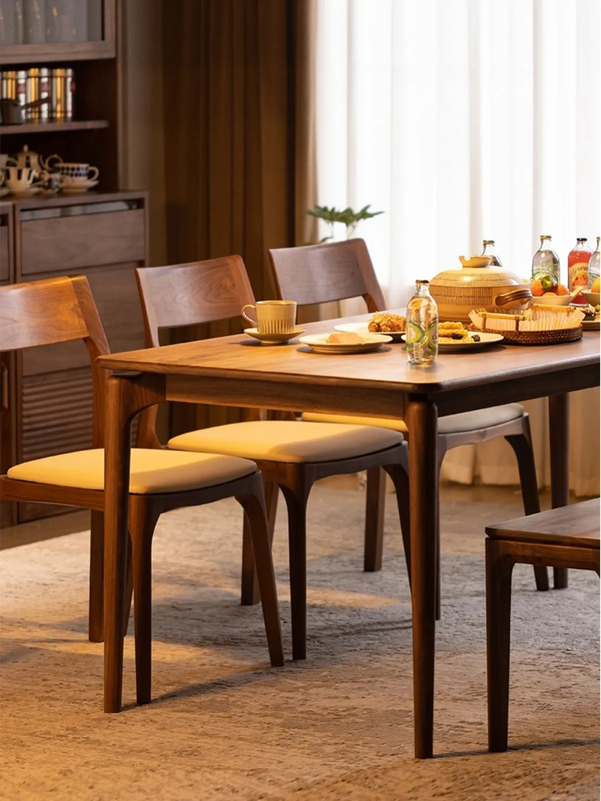 A complete set of Walnutry Japandi black walnut dining chairs arranged around a large rectangular solid walnut table, prepared for a cozy family gathering.