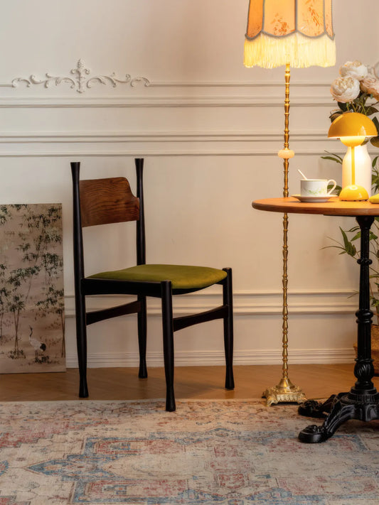 Korin dining chair three-quarter view in a styled interior with floor lamp and round side table