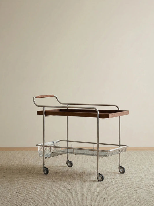 Side view of Walnutry Kurumi solid walnut bar cart highlighting the chrome frame and leather-wrapped handle.