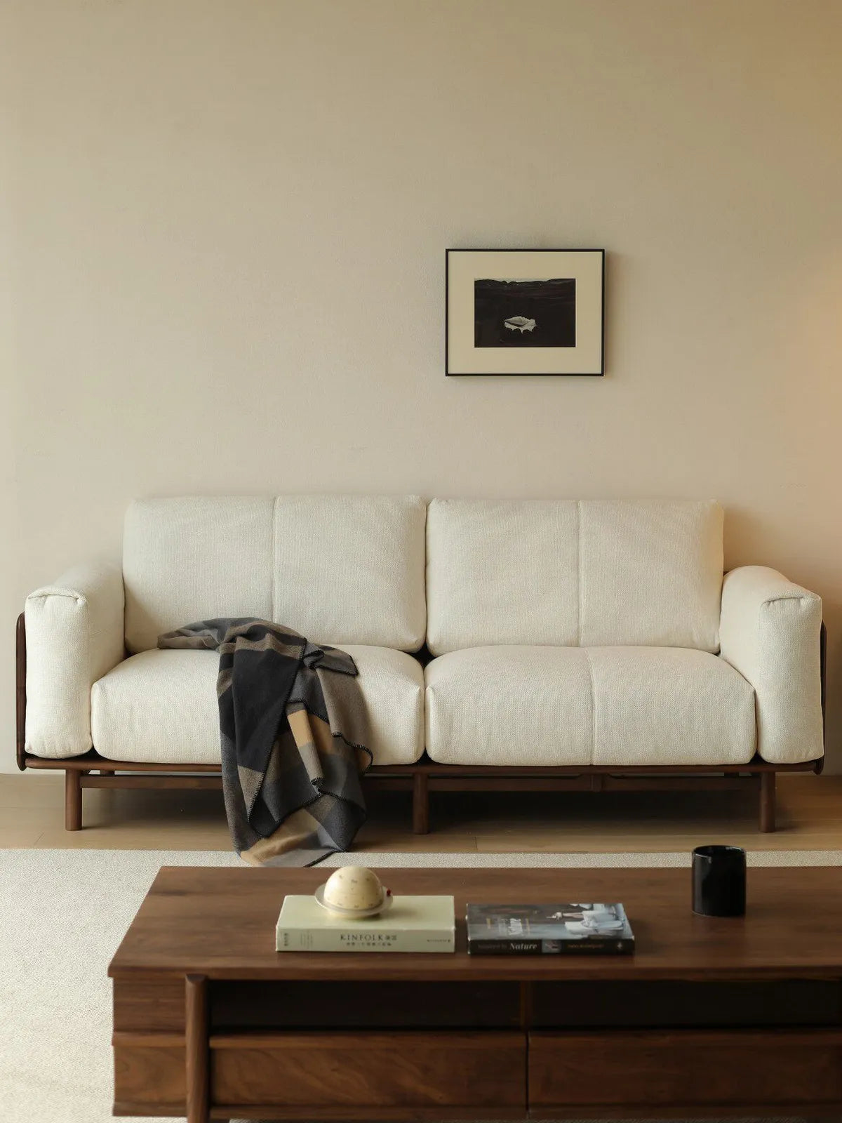 Lior sofa in white fabric styled in a living room with walnut coffee table and framed artwork