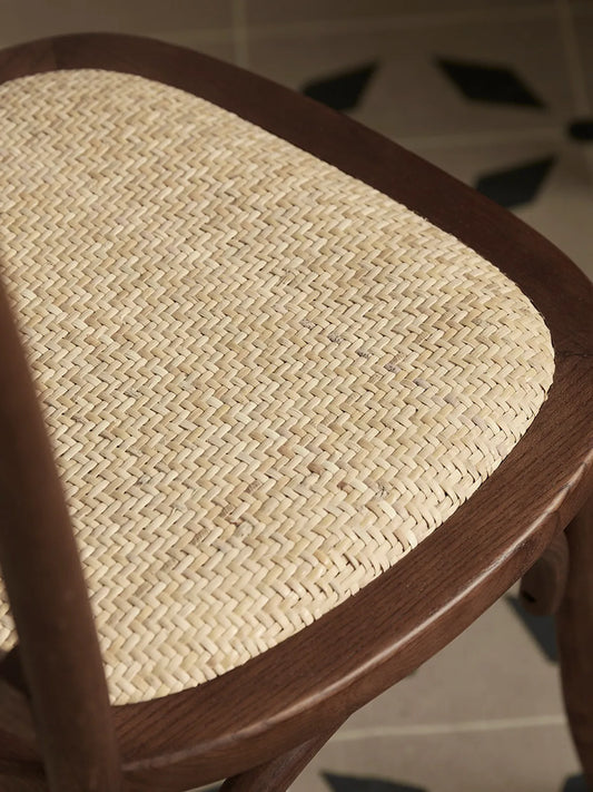 Close-up of the handwoven herringbone rattan seat panel framed by the solid walnut seat ring
