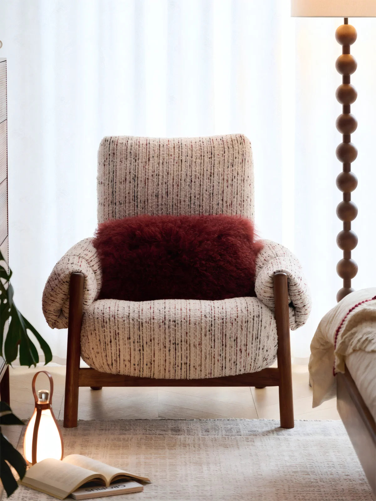Walnutry Marais Armchair front lifestyle view in bedroom, high back armchair with textured fabric upholstery, walnut frame, and soft sculptural cushioning