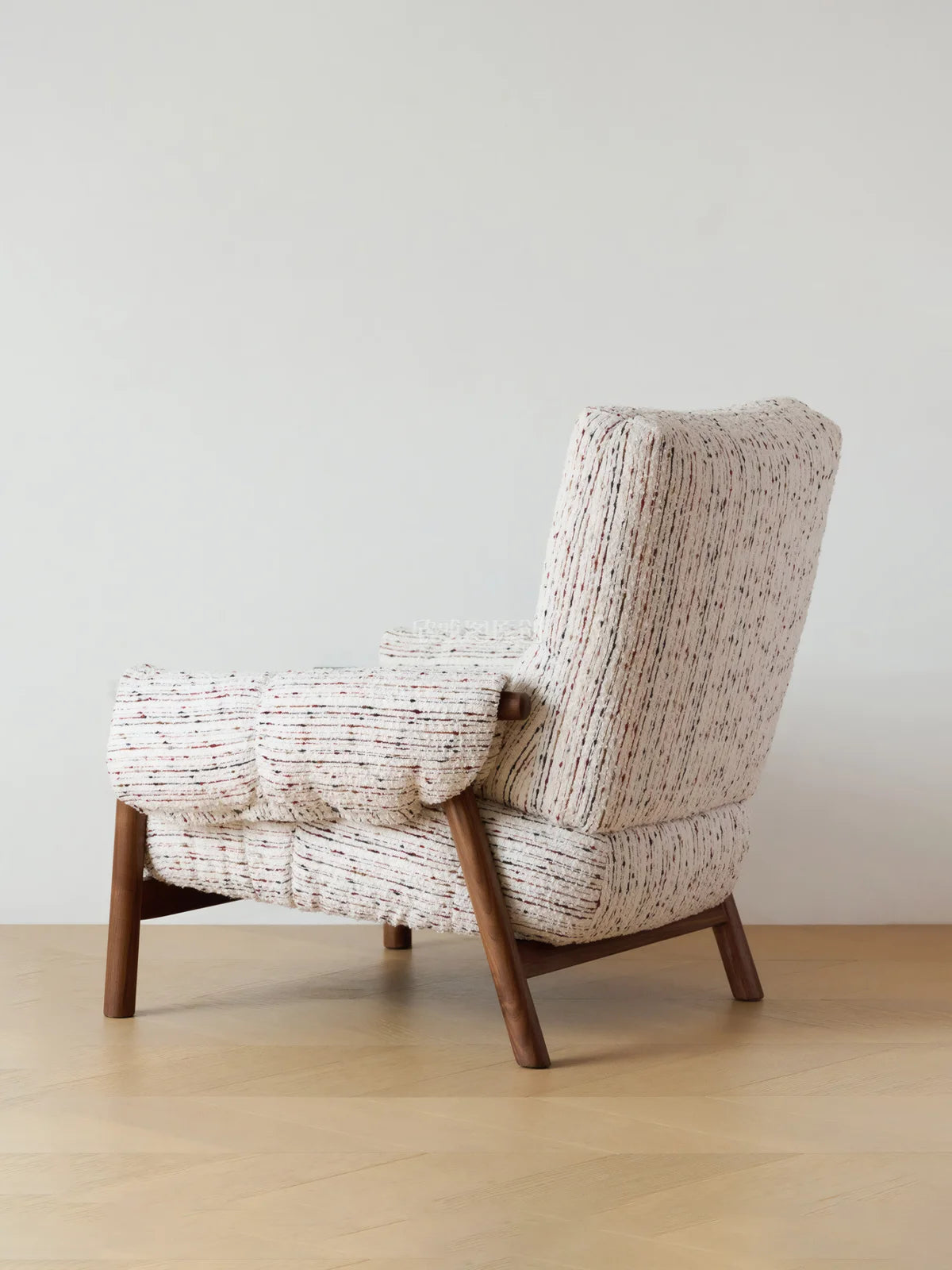 Walnutry Marais Armchair side back view, mid century upholstered armchair with high back profile, wrapped fabric body, and angled walnut wood legs