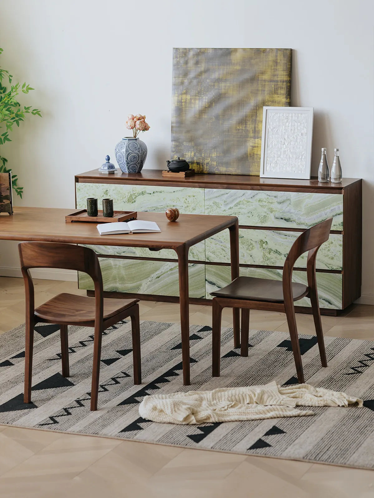 Overhead angled view of two Maren chairs tucked under a walnut dining table showing curved backrests and sculpted seats