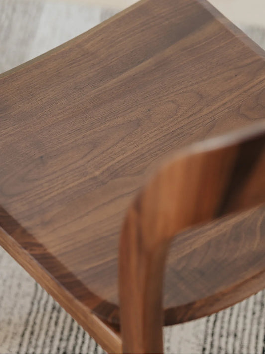 Detail of the Maren chair rear seat edge and backrest joint in solid American black walnut