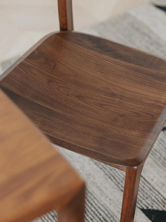 Close-up overhead view of the Maren chair sculpted walnut seat showing natural grain and scooped contour