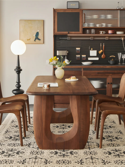 Front view of the Marlow double pedestal dining table styled with walnut chairs in a warm dining room.