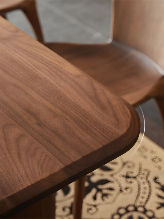Close-up of the Marlow dining table corner showing the softly rounded edge profile and rich walnut grain.
