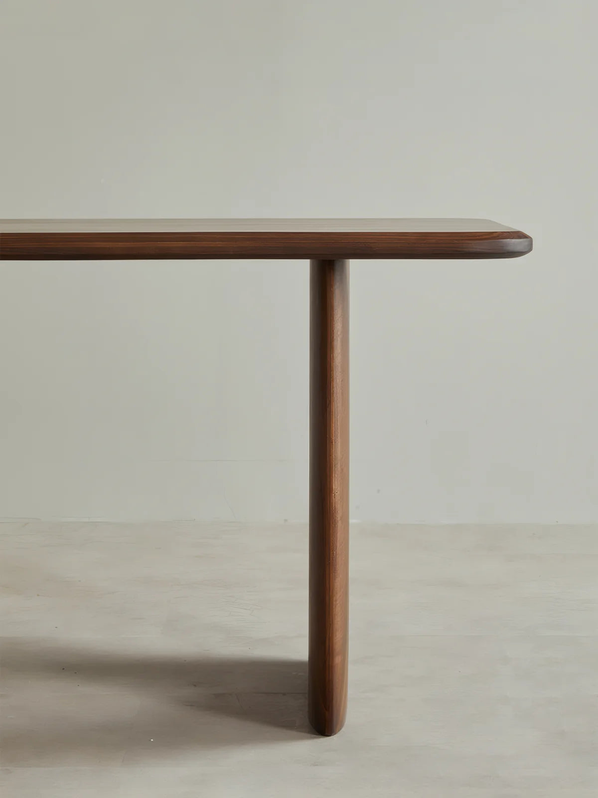 Side profile of the Marlow dining table highlighting the slim top and sculptural pedestal base.