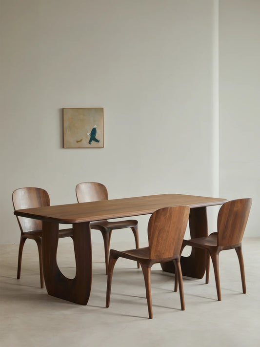 Angled studio view of the Marlow walnut dining table with four matching walnut chairs.