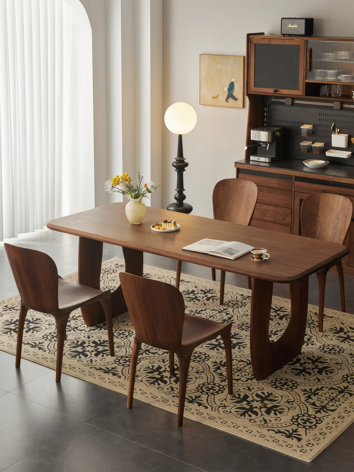 Angled overhead view of the Marlow dining table styled with a vase, dessert plate, book, and cup.