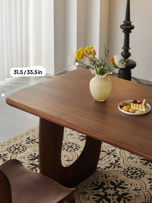 Marlow walnut dining table in a styled interior showing the rounded rectangular top and 31.5 to 33.5 inch depth.