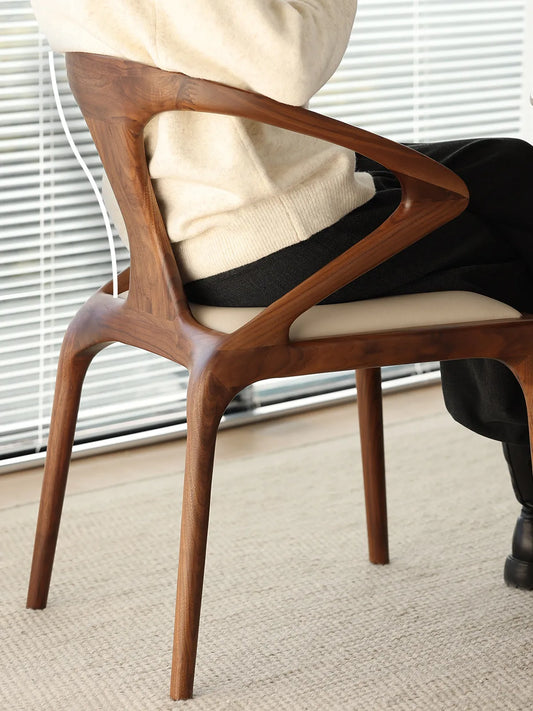 Close-up detail of the curved walnut backrest on these mid century modern kitchen chairs, showing ergonomic support and supreme comfort.
