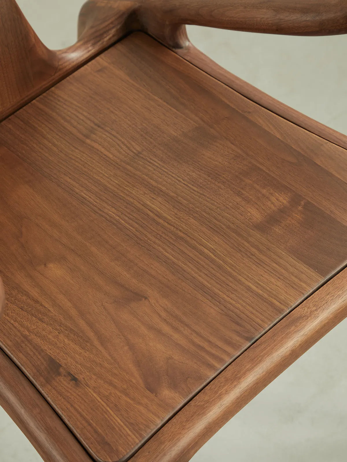 Top-down view of our mid century modern upholstered dining chairs showcasing the rich, natural grain of North American black walnut and the soft seat.