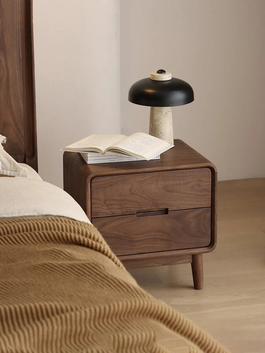 Styled mid century modern walnut nightstand crafted from premium FAS-grade solid wood, featuring decorative bedside accessories.