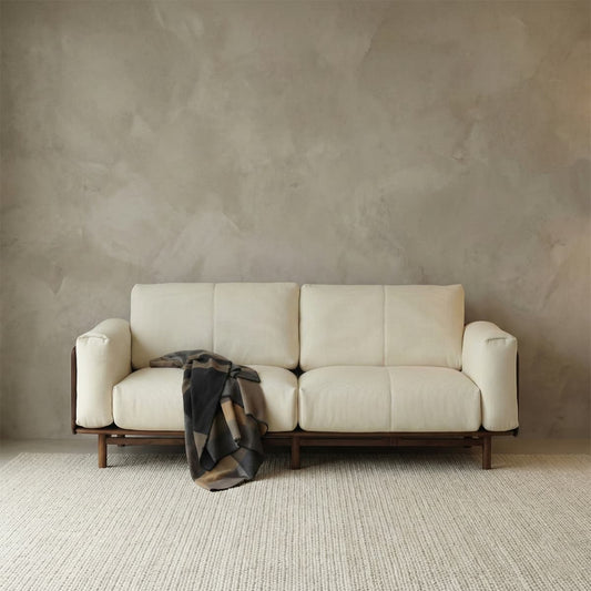 Minimalist 2-seater sofa crafted from solid North American black walnut with premium cream fabric upholstery and soft throw blanket, featuring mortise and tenon joinery.