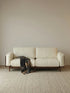 Walnutry minimalist 2-seater sofa upholstered in cream textured fabric, supported by a solid North American black walnut wood frame and legs.