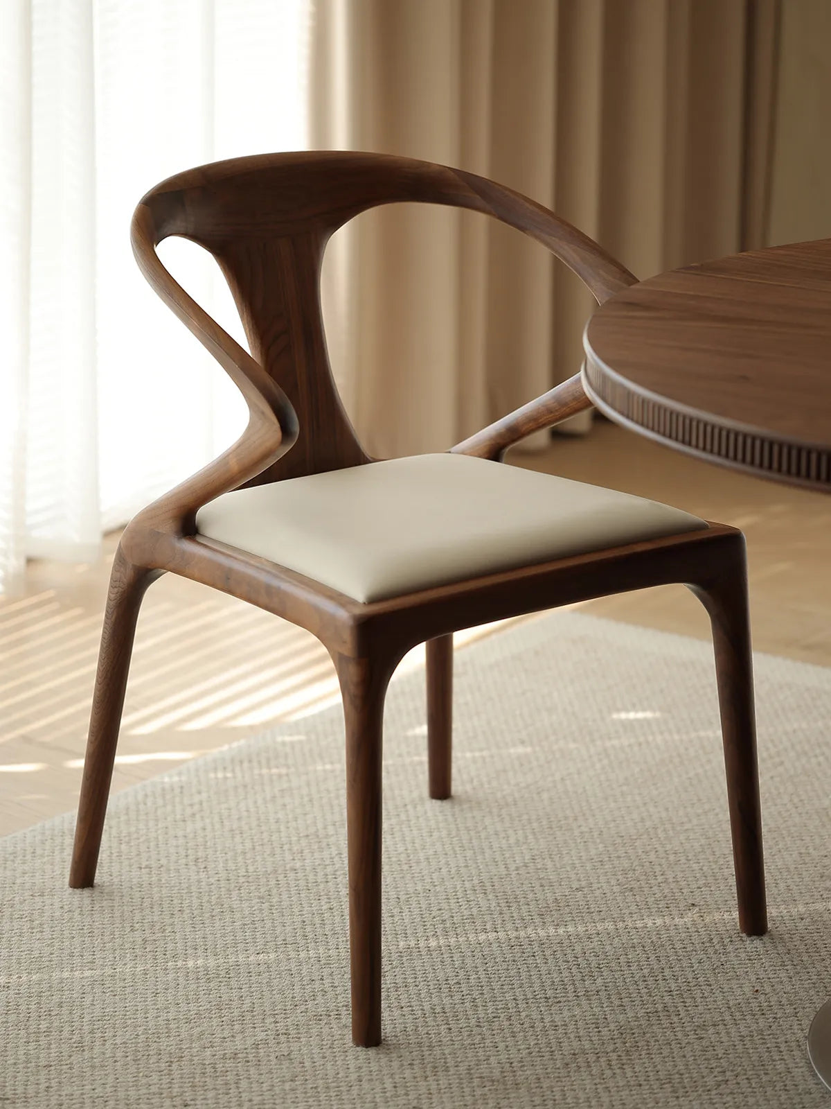 Side profile of the Helios modern mid century dining chair by Walnutry, featuring a sculptural solid wood frame in natural light.