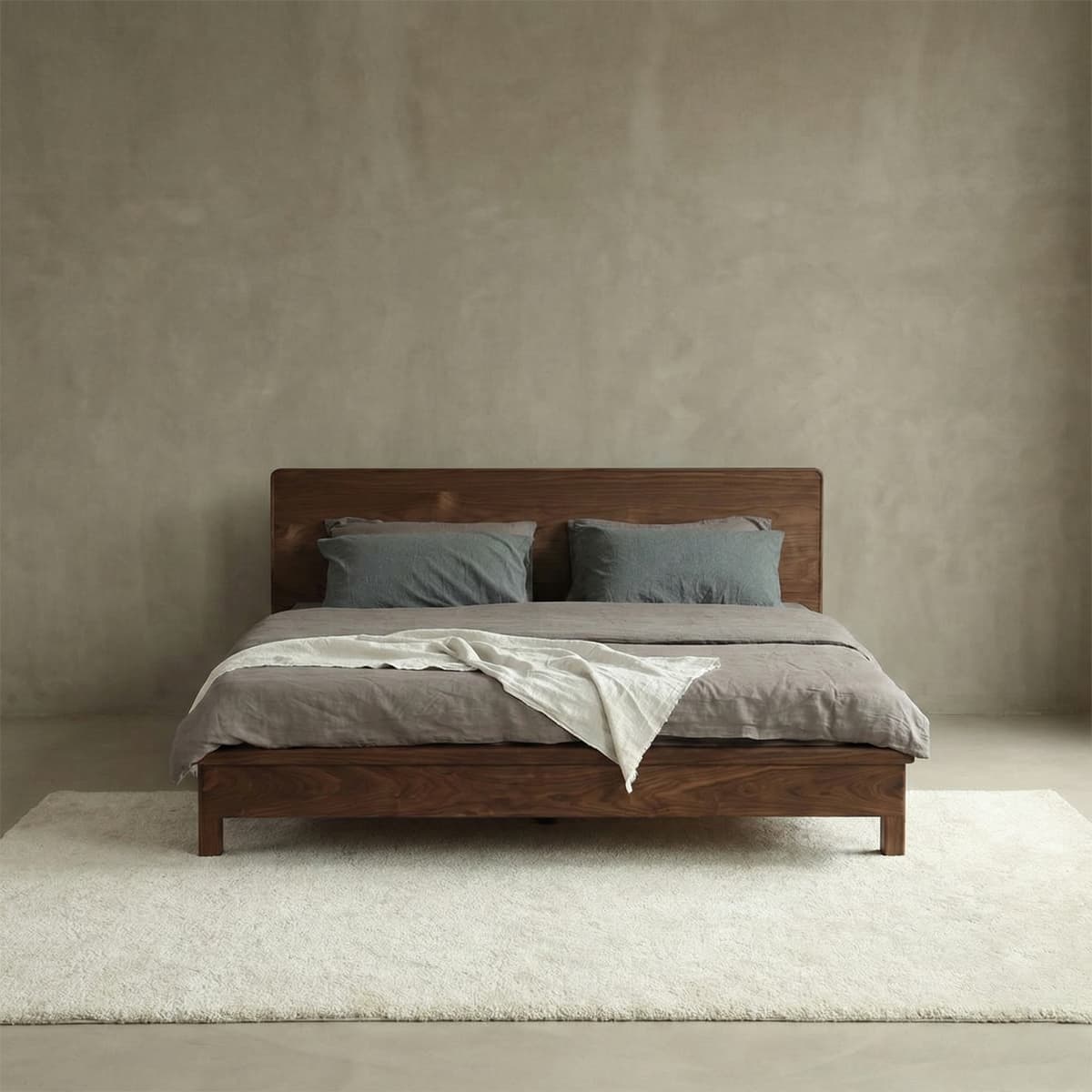 Contemporary solid black walnut platform bed frame with a sleek, rectangular headboard, showcasing the natural beauty of the wood grain in a minimalist bedroom.