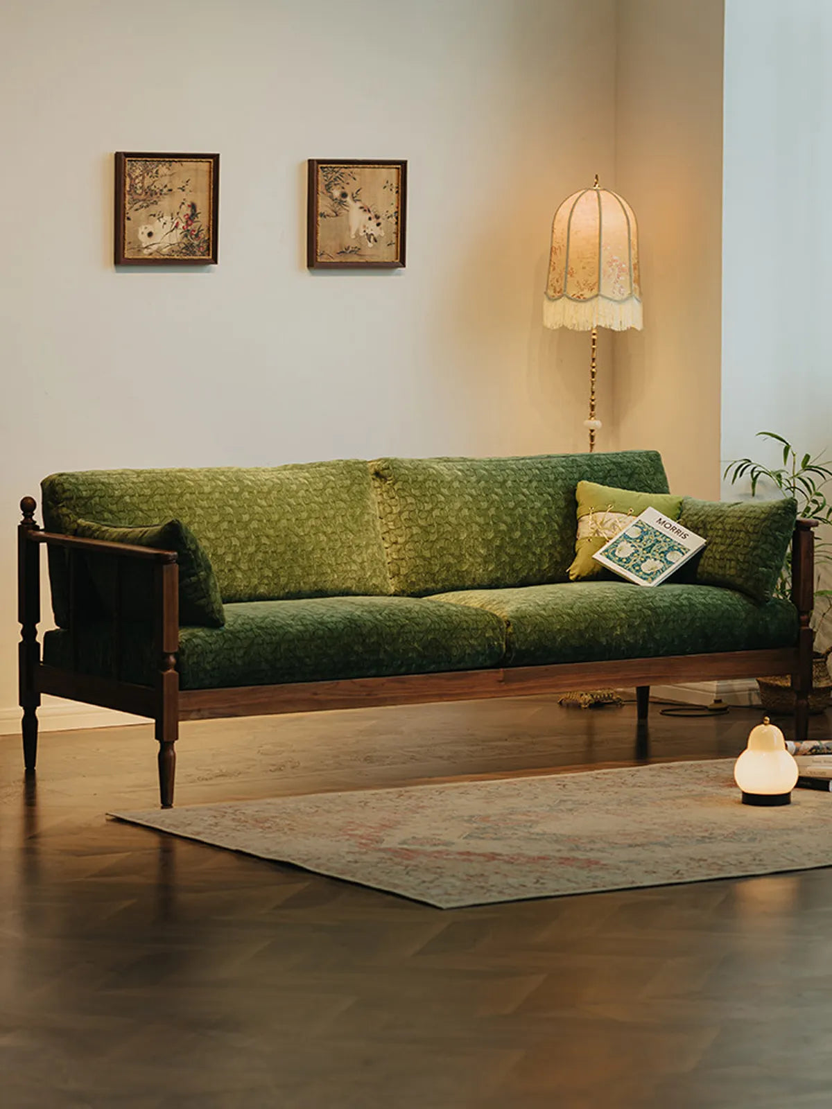 A wide-angle view of the Morris Solid Black Walnut Sofa styled in a premium living space with parquetry flooring.