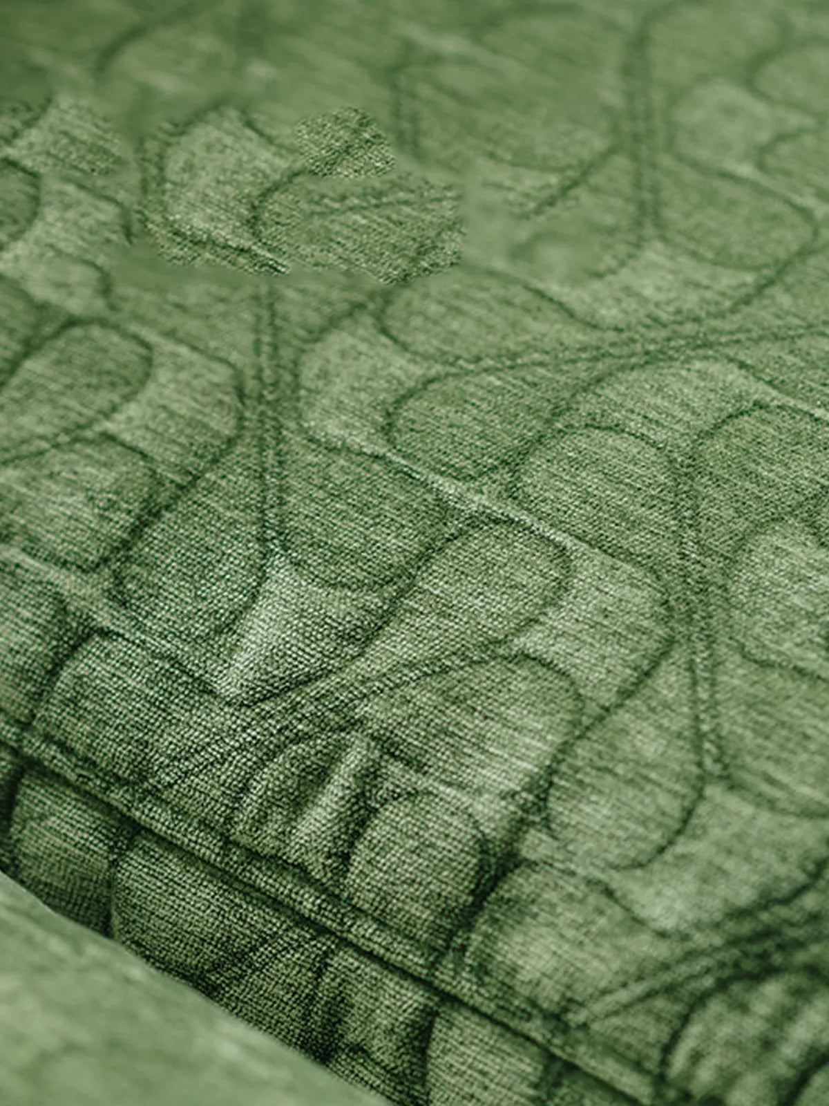 Macro texture shot of the premium green velvet fabric, showing the fine details of the Morris sofa's upholstery.