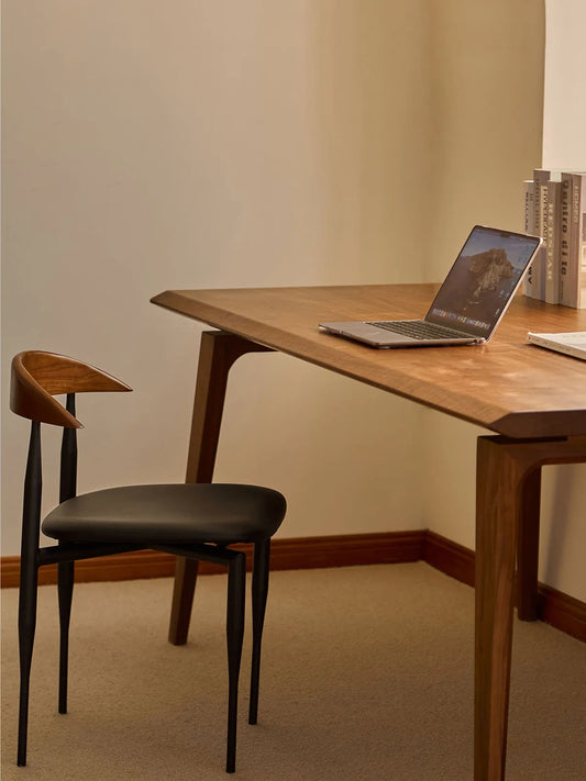 Noren dining chair used as a desk chair beside a walnut writing desk with laptop