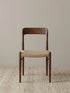 Orin woven cord dining chair in solid American black walnut, front view on neutral rug