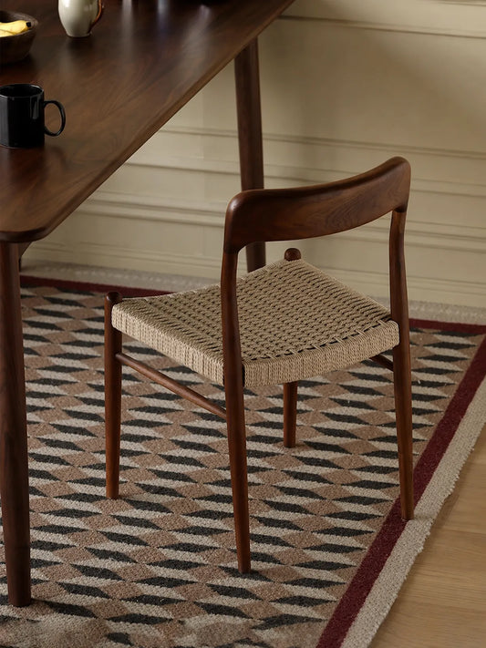 Orin walnut dining chair with paper cord seat seen from behind at a dining table