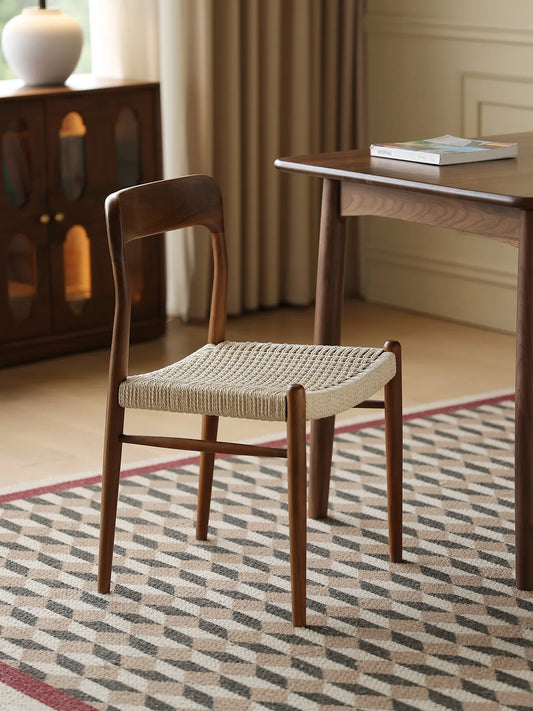 Orin walnut dining chair with woven seat in a styled dining room with walnut table and sideboard