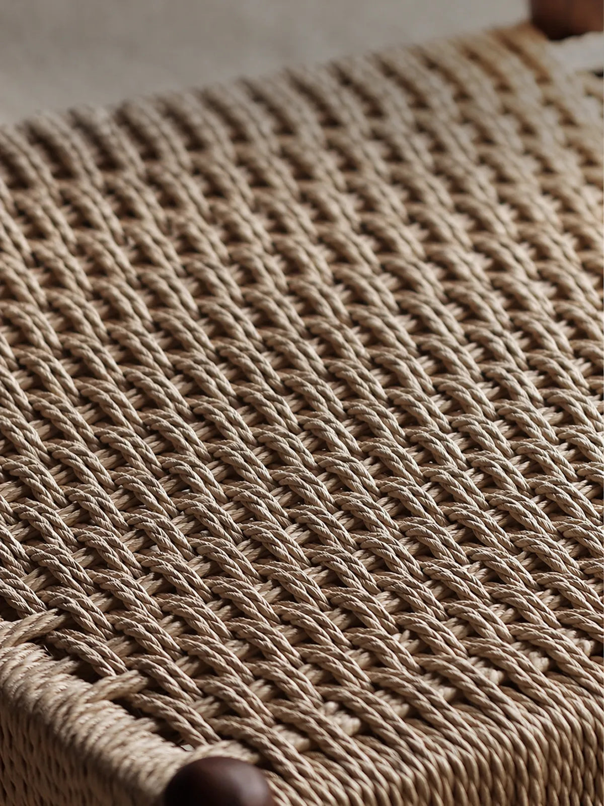 Close-up of hand-woven paper cord seat texture on the Orin dining chair