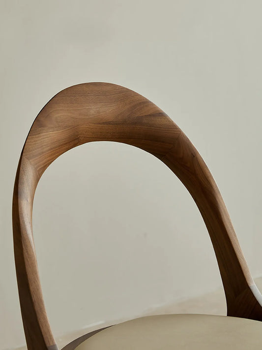 Close-up of the curved walnut backrest showcasing smooth grain and the continuous arch profile.