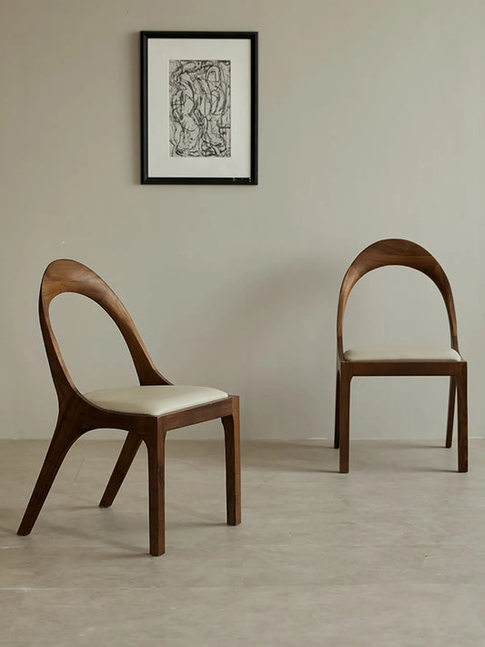 Three-quarter angle of the Oryn dining chair revealing the backrest curve, seat cushion, and leg joinery.
