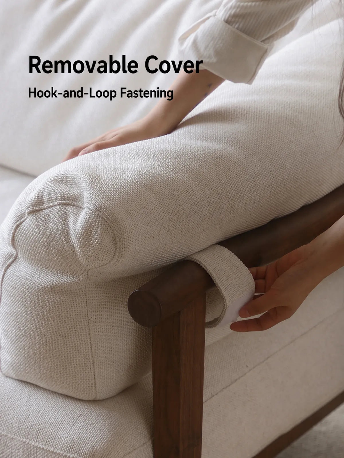Detail of Oslo sofa removable bouclé cushion cover with hook-and-loop fastening on walnut arm