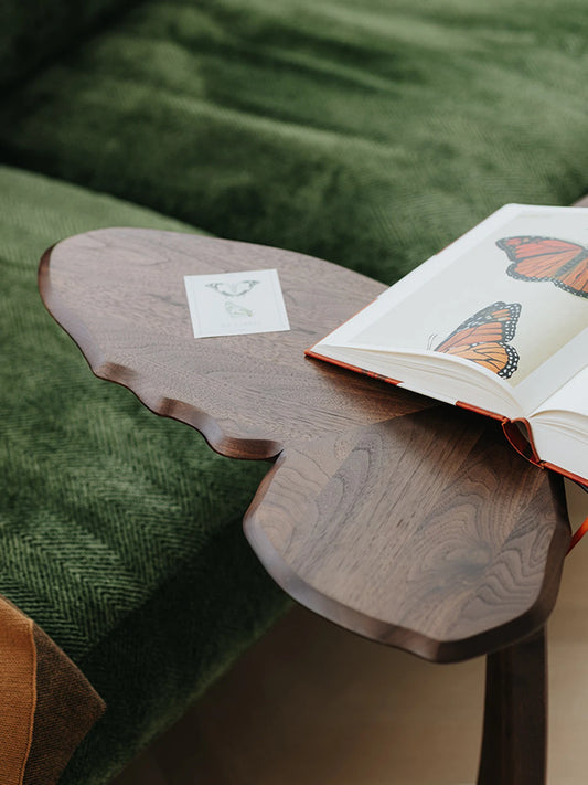 A top-down view of the Papillon accent table featuring the beautiful butterfly-wing design and intricate black walnut wood patterns.
