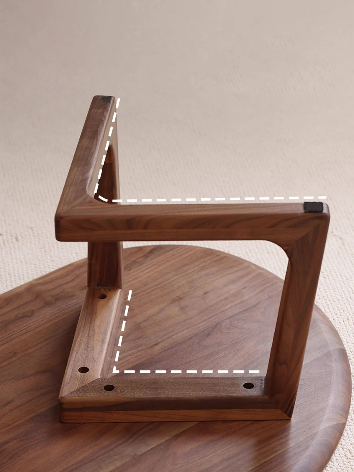 Underneath view of The Pebble Nesting Coffee Table showing the durable V-shaped structural base and protective floor pads.