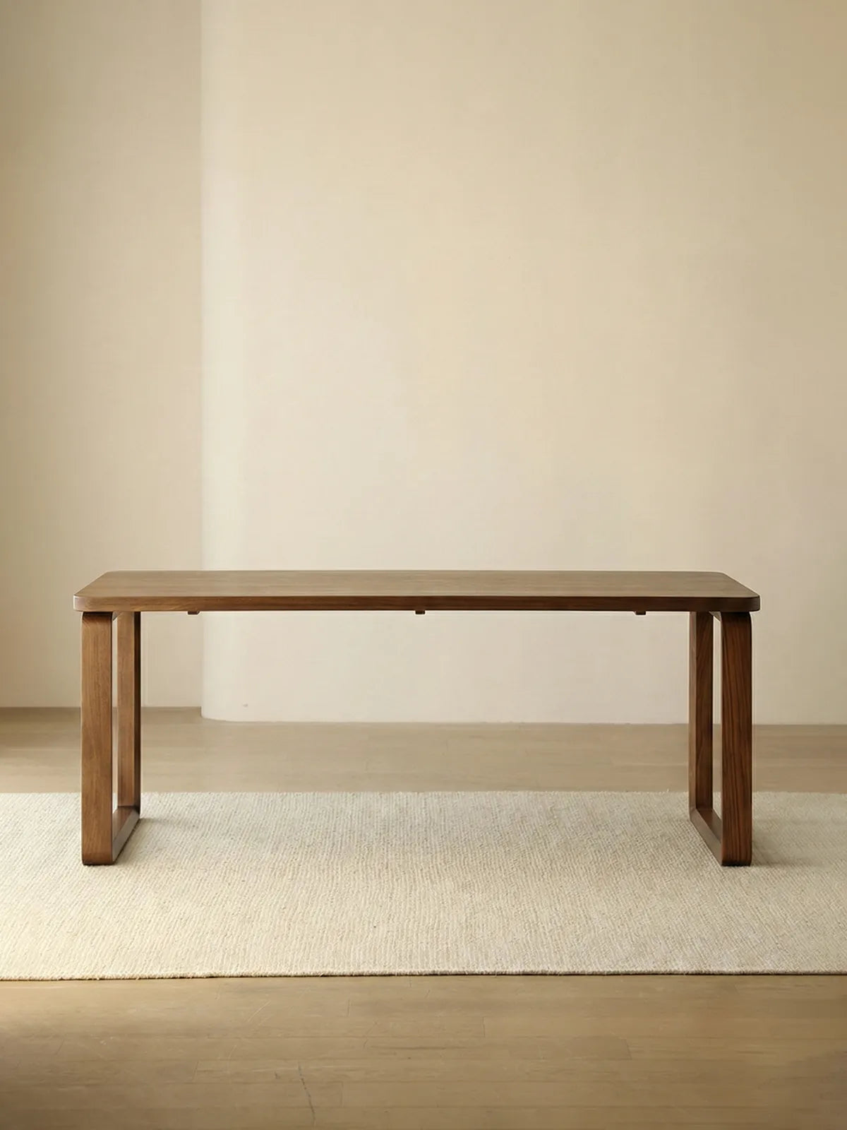Walnutry minimalist rectangular dining table crafted entirely from solid North American black walnut, featuring wide panel legs and a smooth natural finish.
