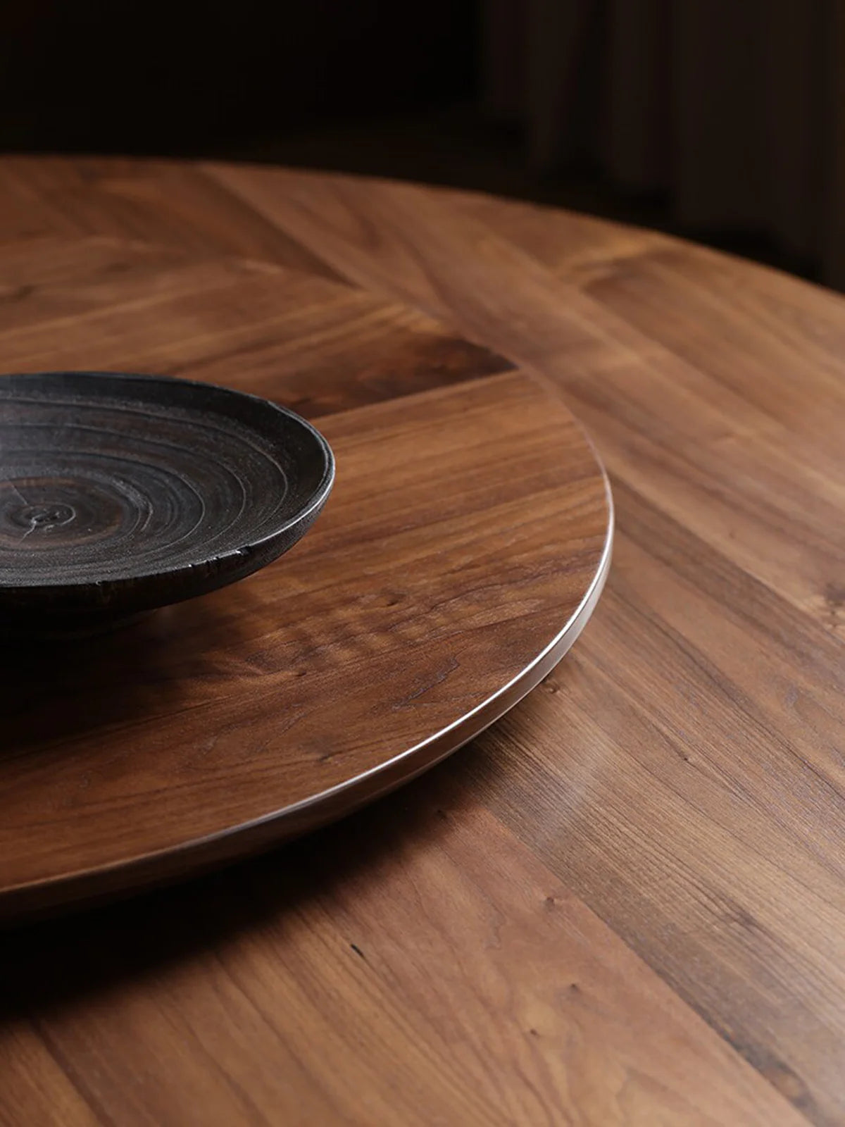 Close-up of the walnut tabletop and lazy Susan, highlighting the rich wood grain and smooth round edge.