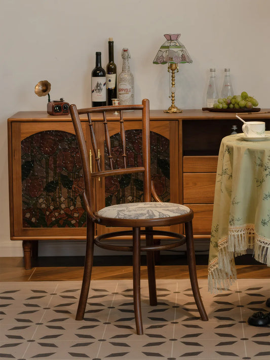 Rear view of the Salo walnut dining chair with toile seat cushion in a styled room with sideboard and patterned tile floor