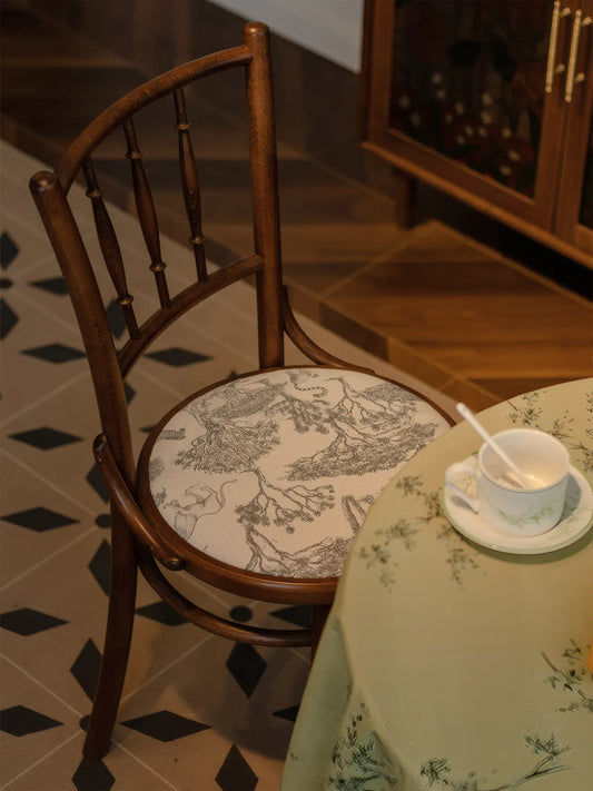 Salo walnut dining chair with toile cushion pad in a café-style setting with patterned tile floor and glass cabinet