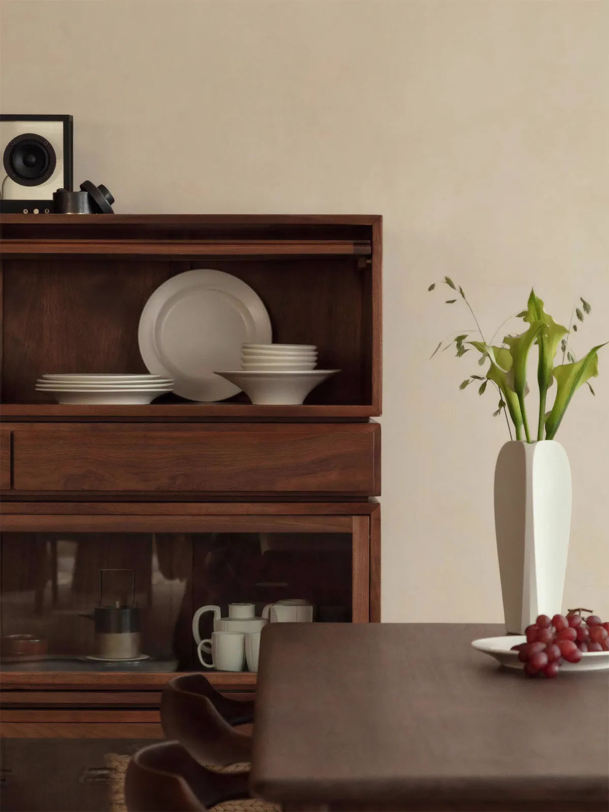 Mid-century modern solid walnut hutch cabinet by Walnutry, featuring sliding doors and open shelving filled with white ceramic dishes.