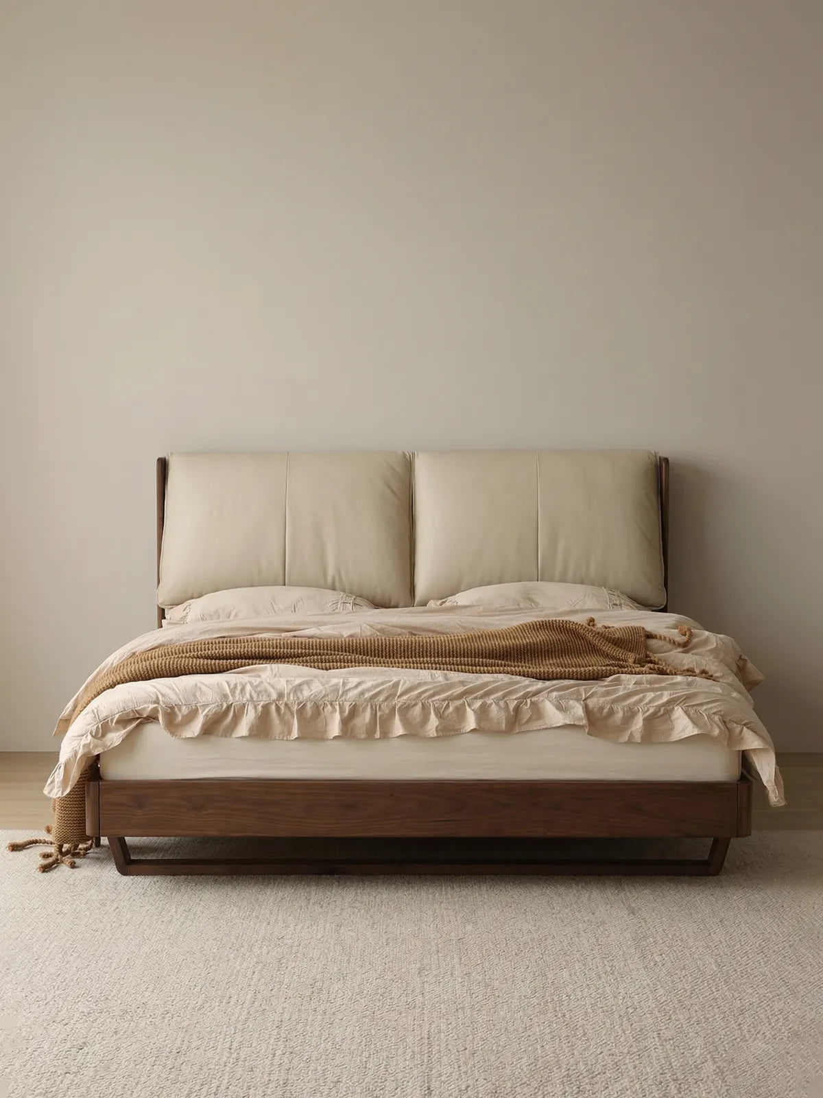 A beautifully styled solid wood platform bed featuring a rich walnut frame and plush cream headboard against a clean white wall.