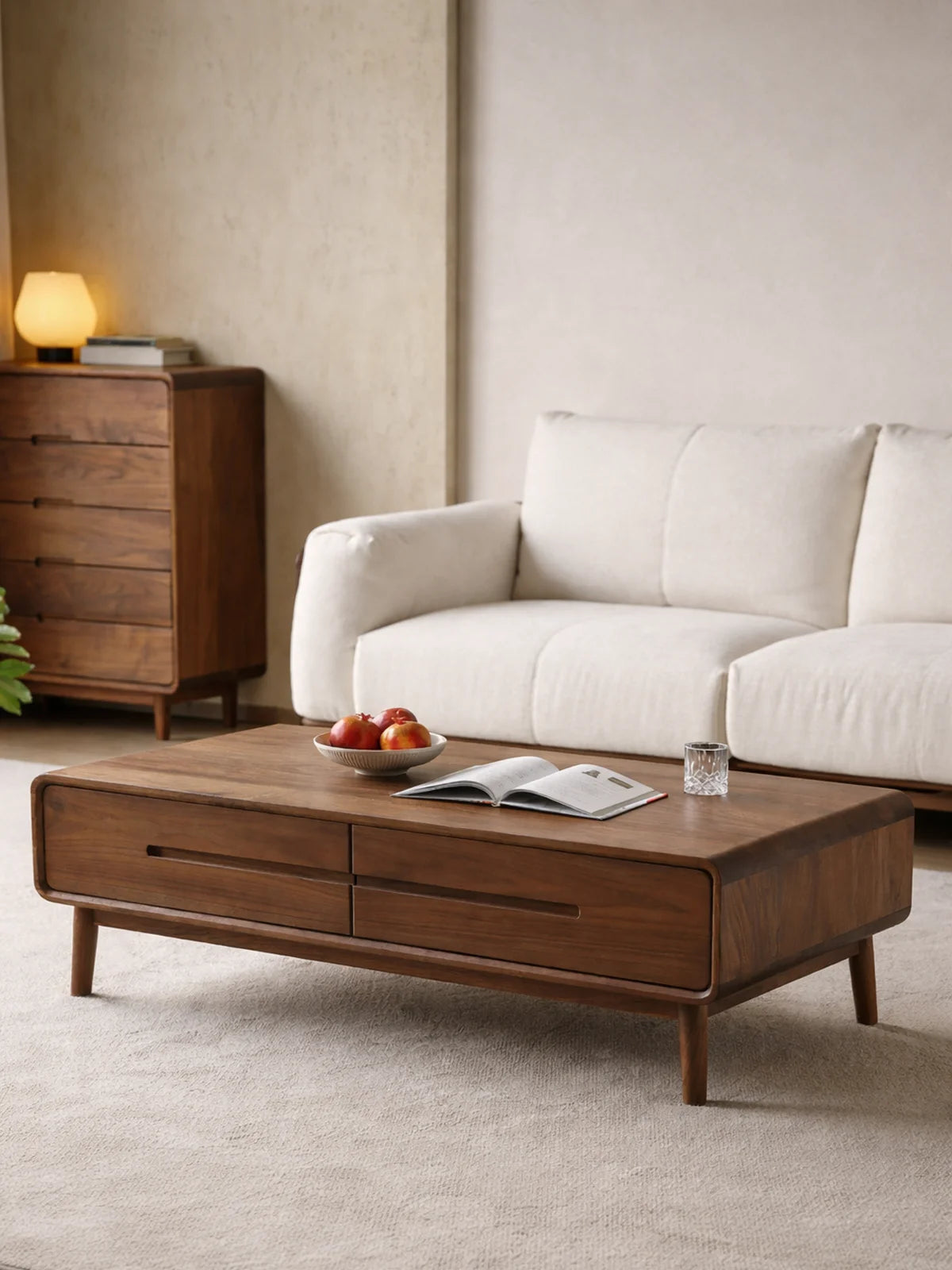Mid century modern walnut coffee table with drawers styled in a calm living room beside a cream sofa