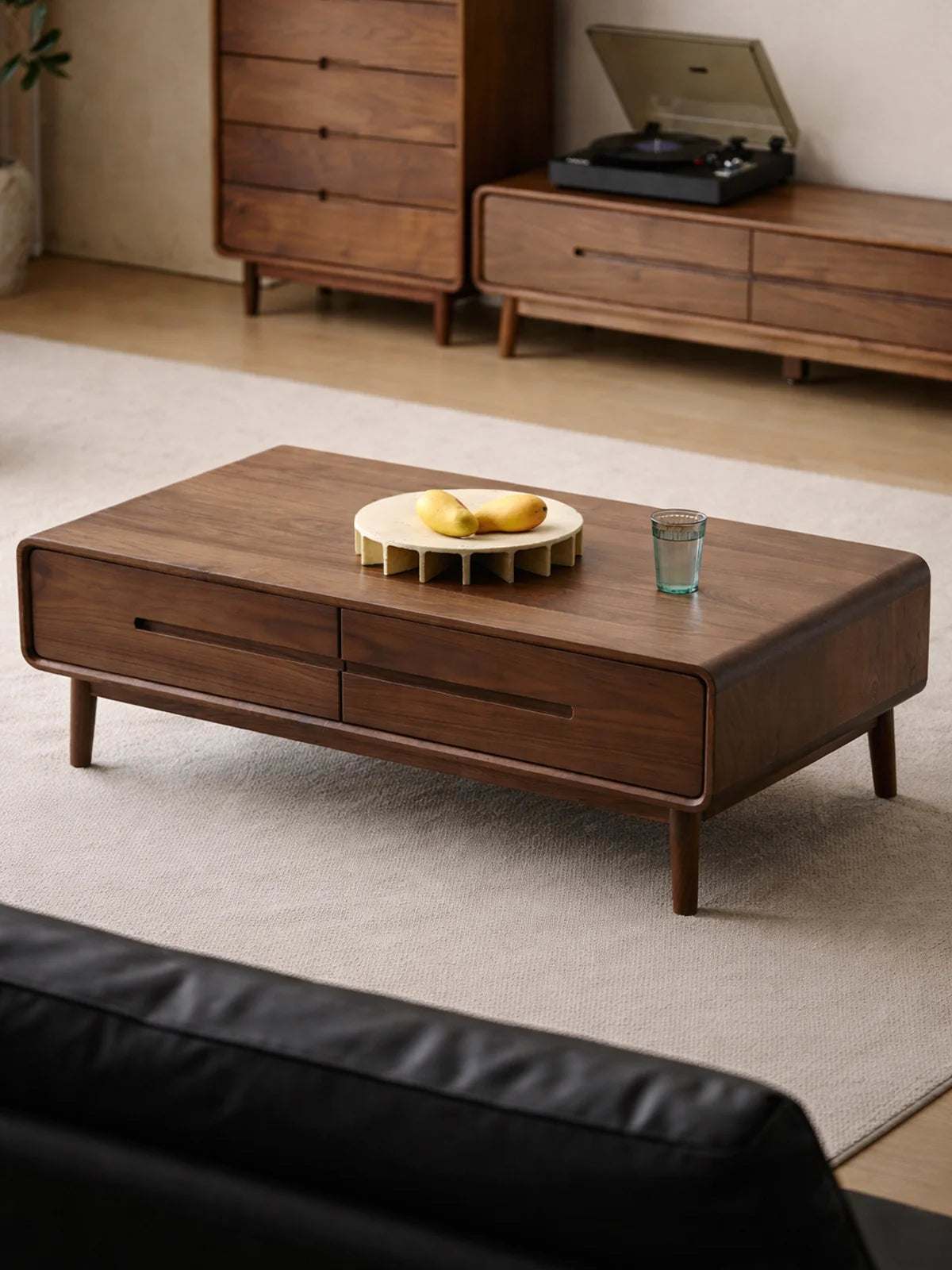 Front three-quarter view of a mid century modern walnut coffee table with tapered legs and double drawers