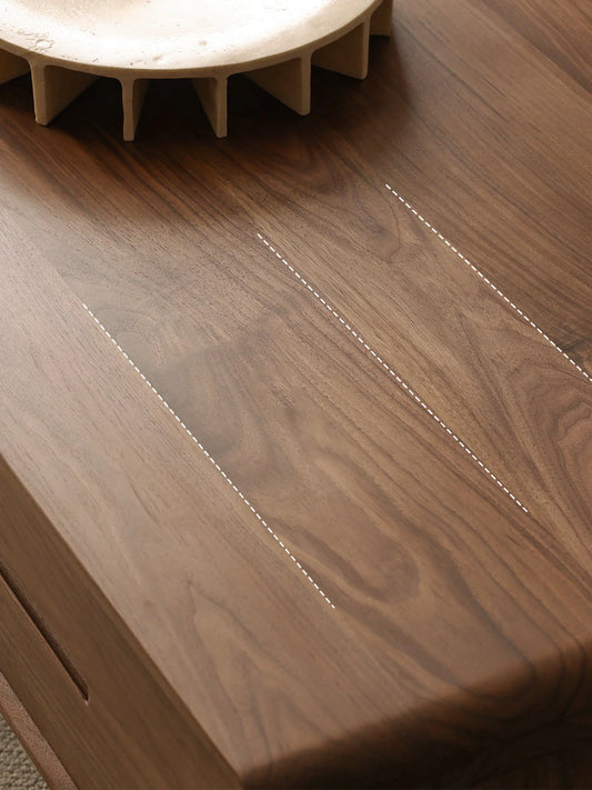 Detail of the rectangular walnut coffee table top showing continuous grain and softly rounded edge profile
