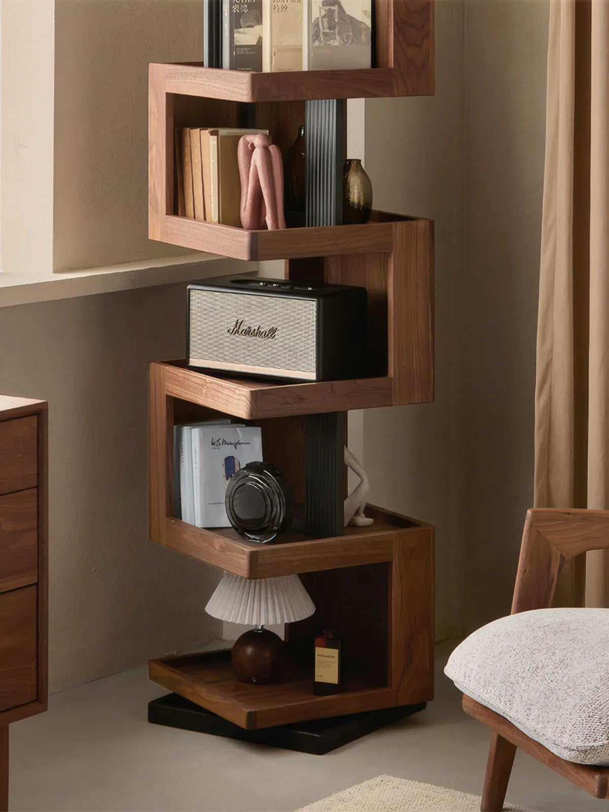 Front view of Walnutry Suiseki solid walnut rotating bookshelf styling with Marshall speaker and art books.