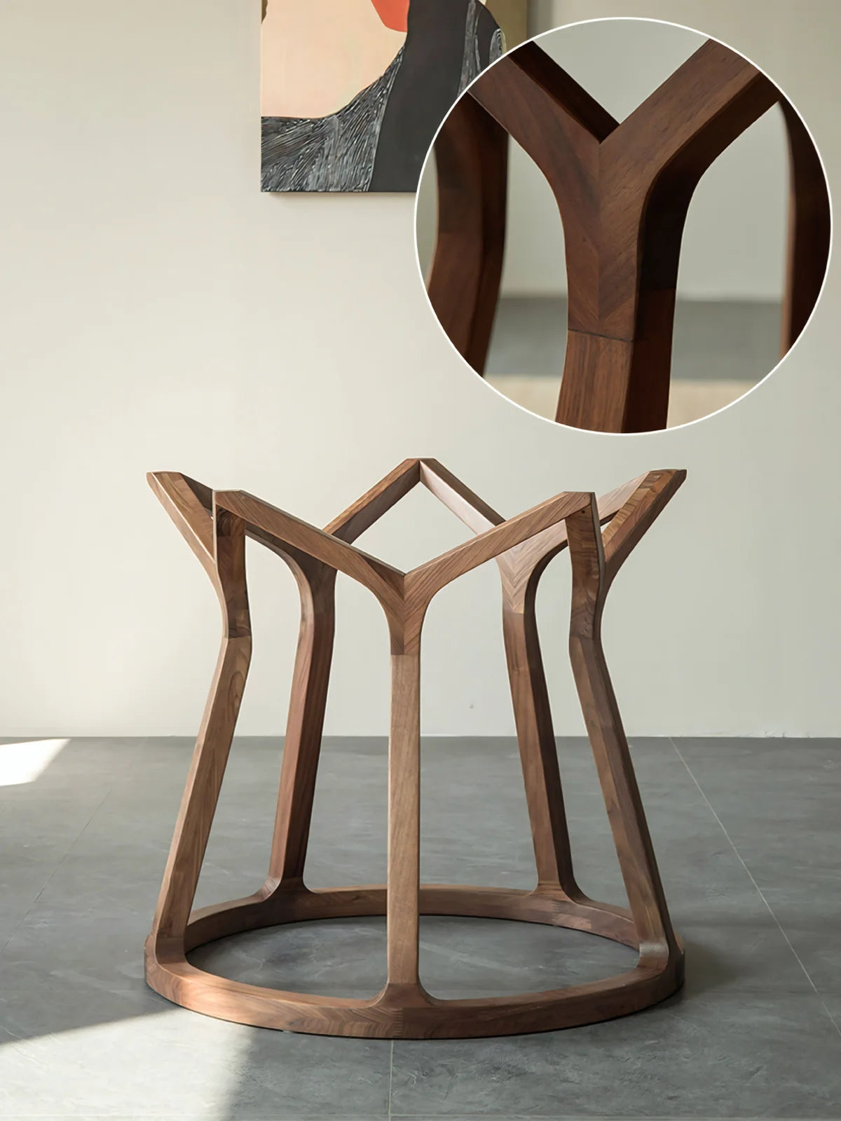 Walnut pedestal base of the round dining table shown on its own, with a close-up detail of the clean joinery and curved support lines.