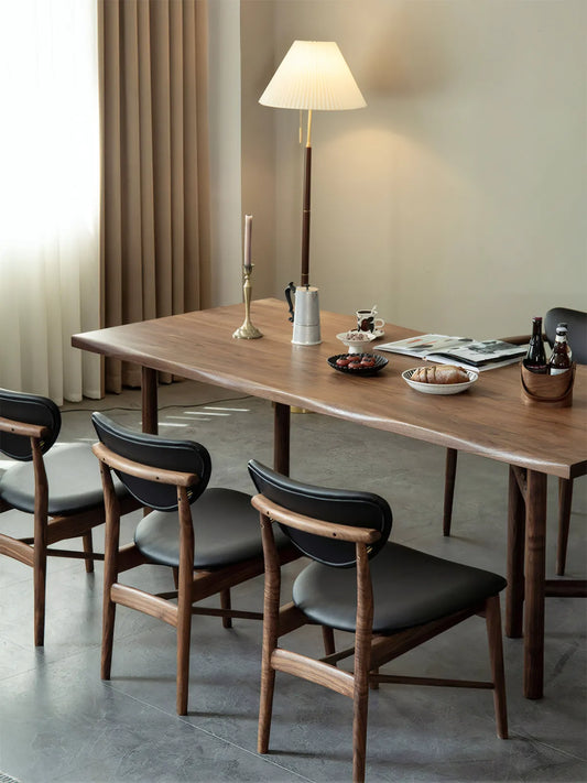 A modern dining room featuring a solid North American Black Walnut table paired with Sylvan mid century modern walnut dining chairs.
