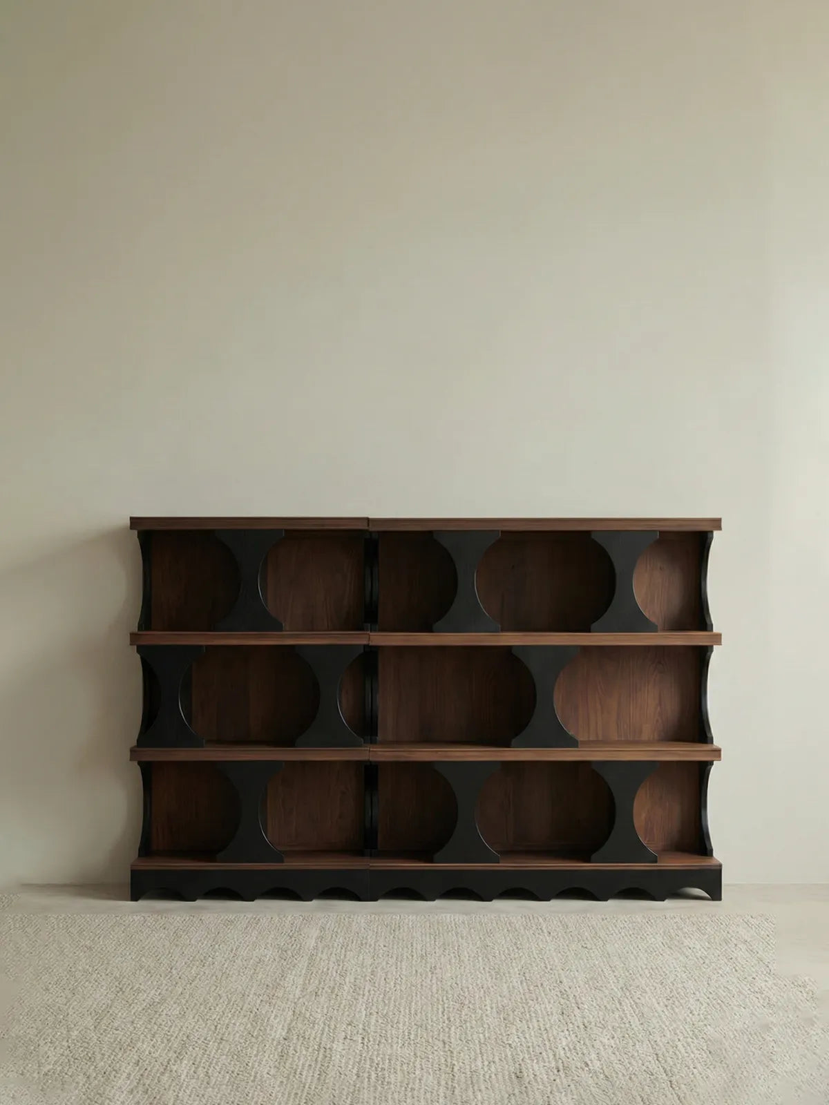 Studio shot of the empty Sylvan solid walnut bookcase against a neutral background, highlighting the asymmetrical mid-century modern design.