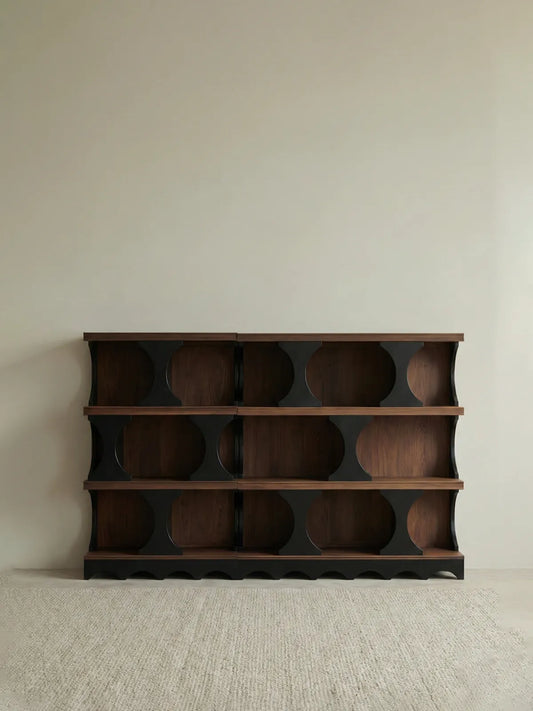 Studio shot of the empty Sylvan solid walnut bookcase against a neutral background, highlighting the asymmetrical mid-century modern design.