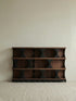 Studio shot of the empty Sylvan solid walnut bookcase against a neutral background, highlighting the asymmetrical mid-century modern design.